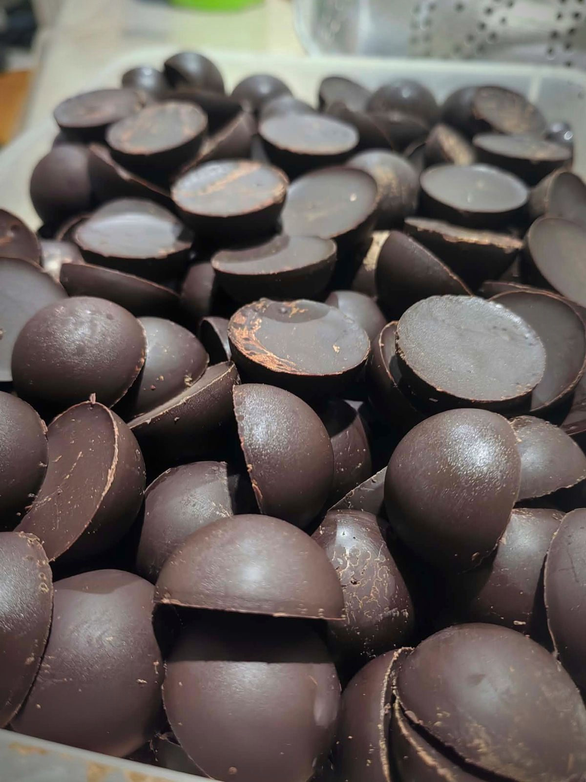 Half-round pieces of pure Cebu cacao tablea, stacked after moulding