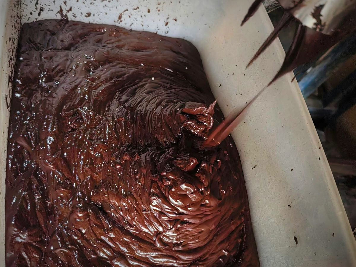 Thick ground cacao paste, ready to be poured into the moulds